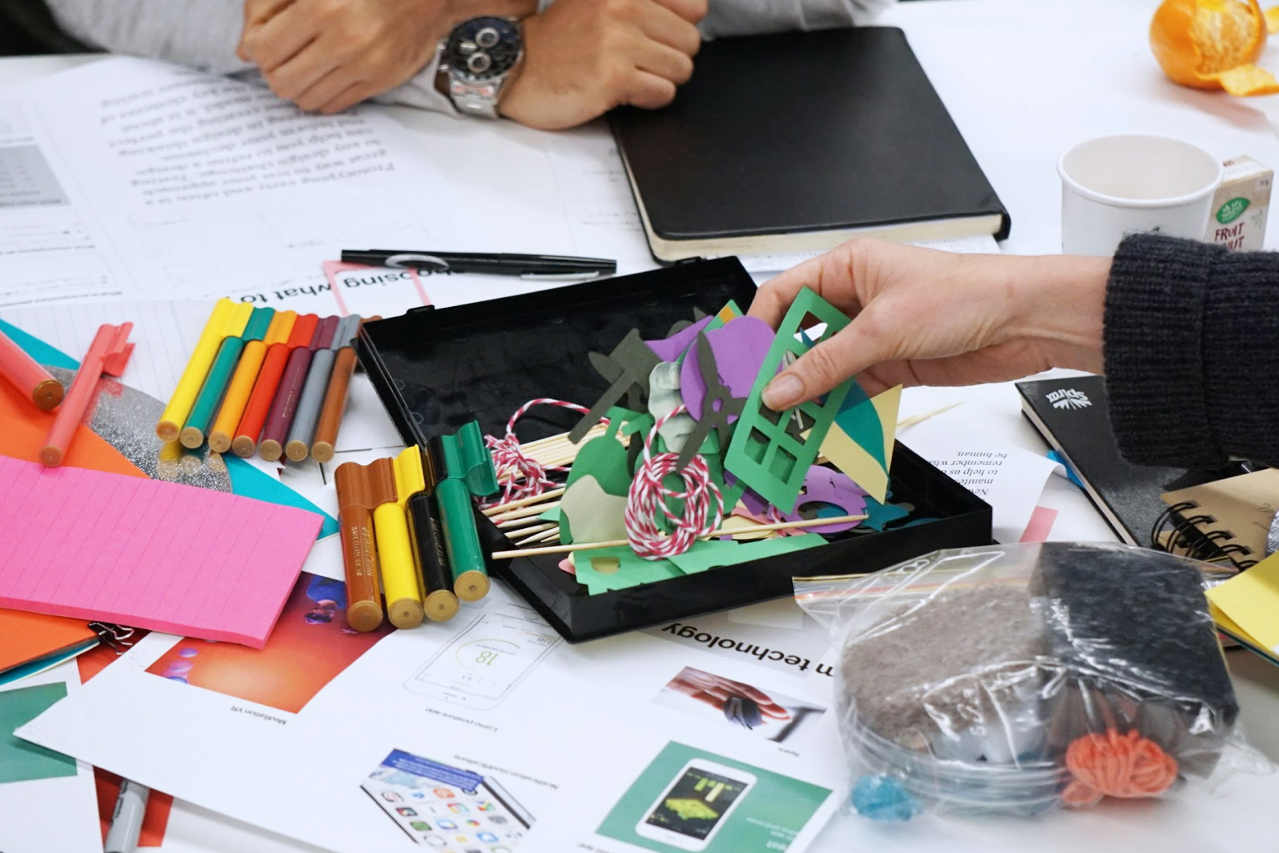 A range of paper and collage materials spread out on a table.
